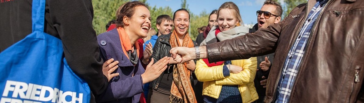 Bild, auf dem eine kleine Gruppe junger Erwachsener zu sehen ist, die im Freien beieinander stehen und ausgelassen ein Schere-Stein-Papier-Spiel beobachten. Das Bild verlinkt auf die Internetseite des Arbeitsbereichs Jugend und Politik der Friedrich-Ebert-Stiftung.